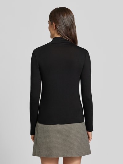 Frauenmodel trägt Longsleeve mit Rollkragen von someday, schwarz, eng anliegend, Ripp-Struktur, Rückenlänge 57 cm, Ganzkörperansicht Rückansicht.