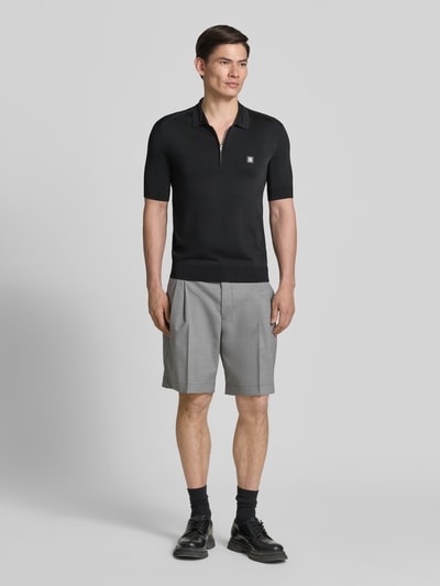 Männermodel trägt Regular Fit Poloshirt aus Viskose-Mix Modell 'SAYFONG-4' von HUGO, unifarben schwarz, Nahaufnahme Ganzkörperansicht von vorne.