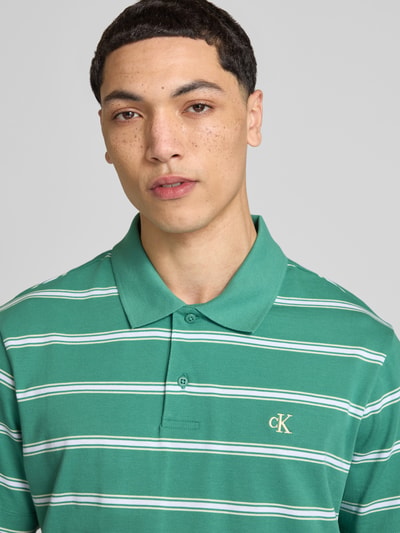 Männermodel trägt Regular Fit Poloshirt mit Logo-Stitching von Calvin Klein Jeans aus Reine Baumwolle, Polokragen, Nahaufnahme Oberkörper.