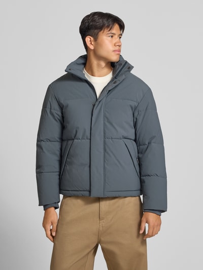 Männermodel trägt Steppjacke mit verdecktem Reißverschluss Modell 'SOHO' von JACK & JONES in Blau, Regular Fit, Ganzkörperansicht von vorne.
