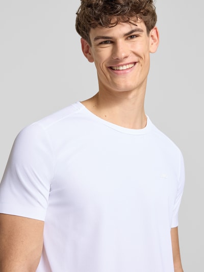 Męski model nosi T-Shirt mit Strukturmuster Modell 'TELLER TEE' od Ellesse, biały, krój regular fit, logo, okrągły dekolt, materiał z domieszką stretchu, zbliżenie na górną część ciała