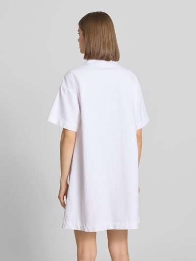 Frauenmodel trägt Loose Fit Jeanskleid aus Baumwoll-Mix Modell 'SKY' von Pieces, weiß, kurzarm, Mini-Länge, Rückansicht Ganzkörperansicht.