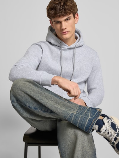 Männermodel trägt Hoodie mit Kapuze Modell 'BRADLEY' von Jack & Jones in Hellgrau, Baumwoll-Mix, lockerer Schnitt, Nahaufnahme Oberkörper.
