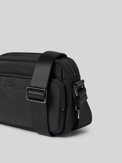 Produktfoto, Crossbody Bag mit Label-Detail von Dsquared2 in Schwarz, rechteckige Form, glatte Textur, Hauptfach mit Reißverschluss, Nebenfach mit Reißverschluss, verstellbarer Schulterriemen, Maße 29 cm Breite, 19 cm Länge, 9 cm Tiefe.