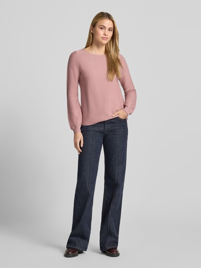 Frauenmodel trägt Pullover aus reiner Baumwolle in Strick-Optik von Christian Berg Woman, rosa Farbe, Jeans, Ganzkörperansicht von vorne. Körpernahe Passform, Rundhalsausschnitt, Rückenlänge 58 cm, Ärmellänge 66 cm.