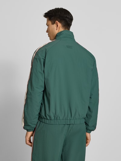 Männermodel trägt dunkelgrünes Trackjacket mit Label-Stitching Modell 'Slipstream' von PROHIBITED, Relaxed Fit, Ganzkörperansicht Rückansicht.