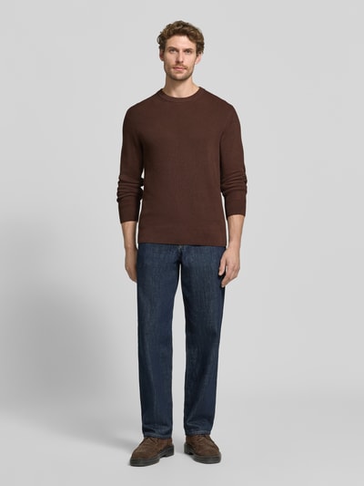 Męski model nosi Regular Fit Strickpullover aus Baumwoll-Mix od MCNEAL, kolor brązowy, okrągły dekolt, elastyczne wykończenia, długość tyłu 65 cm, długość rękawów 56 cm, mieszanka bawełny, Ganzkörperansicht von vorne.