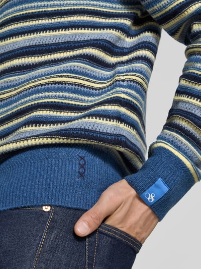 Männermodel trägt Regular Fit Strickpullover mit Streifen-Muster von Scotch & Soda, Blau- und Gelbtöne, Material-Mix, Nahaufnahme Oberkörper