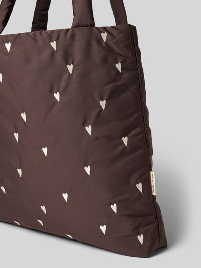 Produktfoto, Tote Bag mit Logo-Detail Modell 'Puffy' von Studio Noos, brauner Stoff mit weißen Herz-Stickereien, strukturierte Oberfläche.