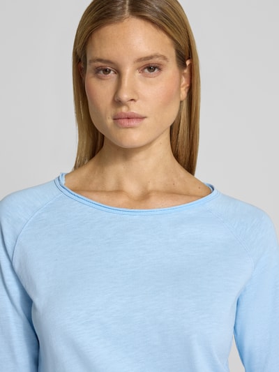 Frauenmodel trägt hellblaues Longsleeve mit Rundhalsausschnitt von Smith and Soul aus reiner Baumwolle, Regular-Fit, Rollsaum, Nahaufnahme Oberkörper.