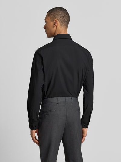 Männermodel trägt Regular Fit Businesshemd mit Kentkragen Modell 'JOE' von BOSS, Optik: Unifarben, Ganzkörperansicht Rückansicht. Passform: Regular-Fit, Knopfleiste: durchgehend, Ärmelabschluss: Manschette, Materialverarbeitung: Performance-Stretch-Jersey, Applikation: Label-Applikation.