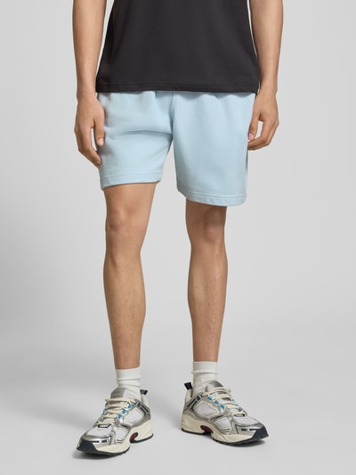 Männermodel trägt Shorts mit Logo-Stitching Modell 'ZANICA' von Ellesse aus Baumwoll-Mix, Relaxed-Fit, Hellblau, Ganzkörperansicht von vorne.