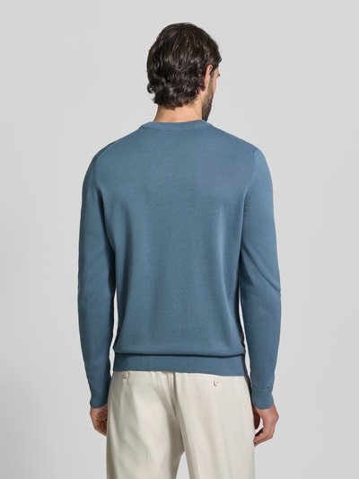 Männermodel trägt Regular Fit Strickpullover aus reine Baumwolle Modell 'SAN CASSIUS-C2' von HUGO in Hellblau, unifarben, Ganzkörperansicht Rückansicht.