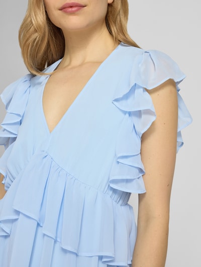 Vrouwenmodel draagt lichtblauwe cocktailjurk met volants, recht model, V-hals, midi-jurk, model 'MUSSI' van YAS, detailopname bovenlichaam.