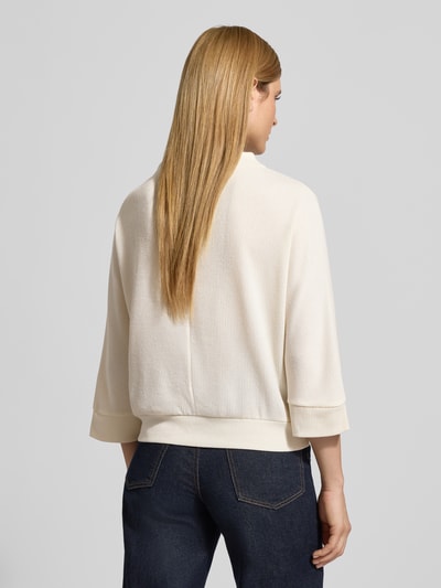 Vrouwenmodel draagt Shirt met lange mouwen met 3/4-mouwen model 'Sagida' van Opus, materiaalmix met viscose, los model, opstaande kraag, ribboorden, ruglengte bij maat 36: 60 cm, lichte kleur, textuur geribbeld, Ganzkörperansicht Rückansicht.