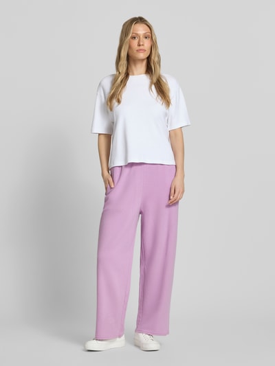 Vrouwenmodel draagt sweatpants met elastische band model 'ATUBAY' van American Vintage, mix van katoen en elastaan, wide leg, tunnelkoord, binnenbeenlengte maat M 70 cm, full body frontaal.