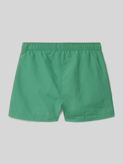 Productfoto, Badehose mit Eingrifftaschen und Logo-Print van CHAMPION voor kinderen, loose fit, elastische band met trekkoord, zij-steekzakken, logoprint. Groene kleur, gladde stof, eenvoudige rechte vormen.