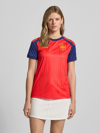 Frauenmodel trägt Spanien Heimtrikot 2026 von adidas Sportswear in Mehrfarbig, Regular-Fit, Logo-Patch, Logo-Detail, Rundhals, Kurzarm, Ganzkörperansicht von vorne.