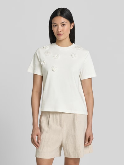 Frauenmodel trägt T-Shirt mit floralen Applikationen von Christian Berg Woman, Reine Baumwolle, Gerader-Schnitt, Rundhalsausschnitt, 1/2-Arm, Rückenlänge bei Größe S: 52 cm, helle Farben und glatte Textur, Ganzkörperansicht von vorne.
