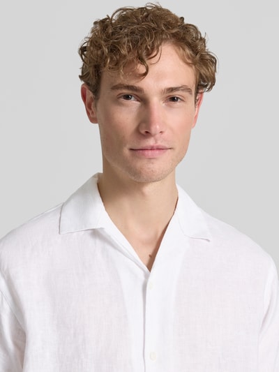Männermodel trägt Regular Fit Leinenhemd Modell 'LAWRENCE' von Jack & Jones Premium in Weiß, Reverskragen, Nahaufnahme Oberkörper.