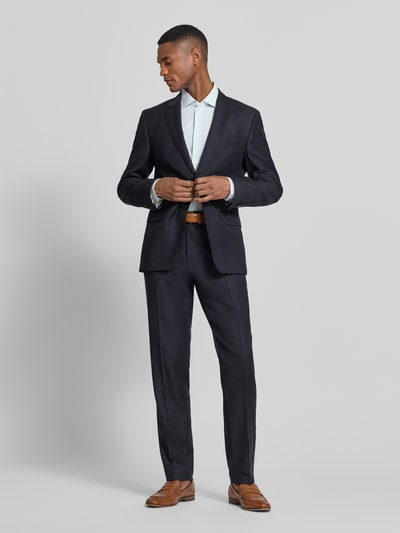 Männermodel trägt Slim Fit Businesshemd aus Baumwoll-Mix von Tommy Hilfiger, efekt: wzór w paski, krój slim fit, kołnierzyk typu kent, listwa guzikowa na całej długości, długi rękaw z mankietem zapinanym na 1 guzik, regulacja szerokości, okrągły dół, mieszanka bawełny, wyhaftowane logo, całe ciało widoczne z przodu
