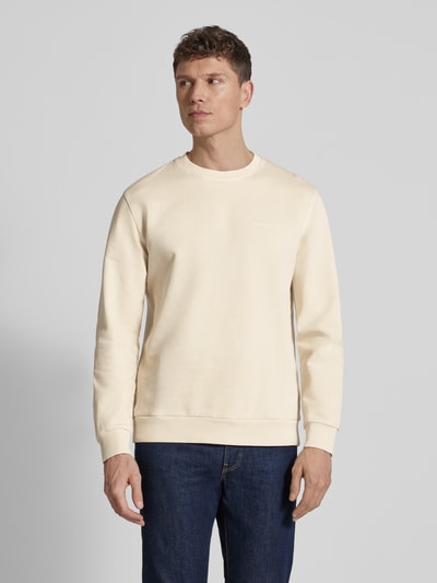 Männermodel trägt Regular Fit Sweatjacke aus reiner Baumwolle von Marc O'Polo in Unifarbe, Label Print, gerippte Abschlüsse, Ganzkörperansicht von vorne.