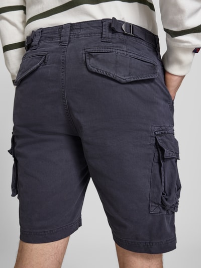 Männermodel trägt Straight Fit Shorts mit Cargo-Taschen Modell 'Core' von Superdry aus Elastischer-Baumwoll-Mix in Dunkelblau, Ganzkörperansicht Rückansicht. Bundweite 42 cm, Innenbeinlänge 23 cm, Herren Shorts mit Cargo-Taschen, Knopf- und Reißverschluss sowie Eingriff- und Gesäßtaschen.