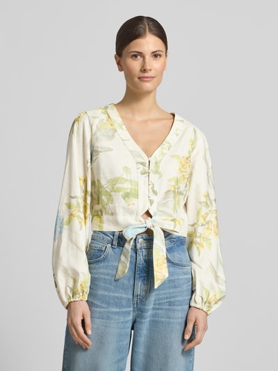 Frauenmodel trägt Cropped Bluse aus Leinen-Viskose-Mix Modell 'SHIRLEY' von Guess mit floralem Muster, V-Ausschnitt, Knopfleiste, Pastelltönen, Nahaufnahme Oberkörper.