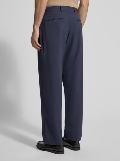 Männermodel trägt Loose Fit Anzughose mit Viskose-Anteil Modell 'LIAM' von SELECTED HOMME, dunkelblau, unifarben, knitterfreie Textur, Ganzkörperansicht Rückansicht