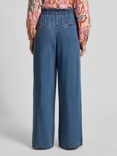 Frauenmodel trägt Hose aus Lyocell mit Tunnelzug Modell 'REESE' von SUNCOO PARIS in Dunkelblau, Wide Leg, Ganzkörperansicht Rückansicht.