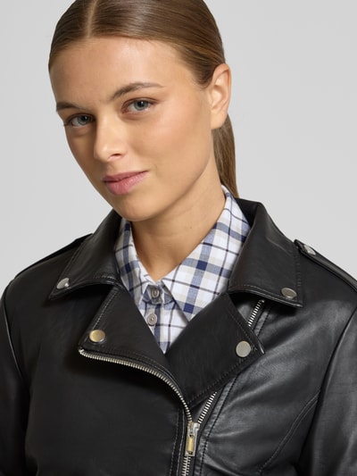 Kobiece model nosi czarną Jackę w stylu skóry model 'CARA' marki Vila, regularny krój, kołnierz koszulowy, zamek, kieszenie, zbliżenie górnej części ciała.