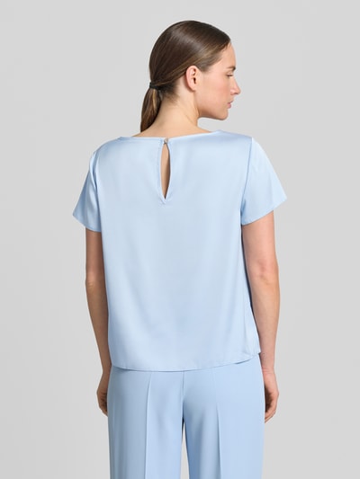 Frauenmodel trägt Blusenshirt mit Rundhalsausschnitt und abgerundetem Saum von Rinascimento im hellblauen Material-Mix mit Stretch-Anteil, Loose-Fit, Rückenlänge bei Größe S: 52 cm, Ganzkörperansicht Rückansicht.