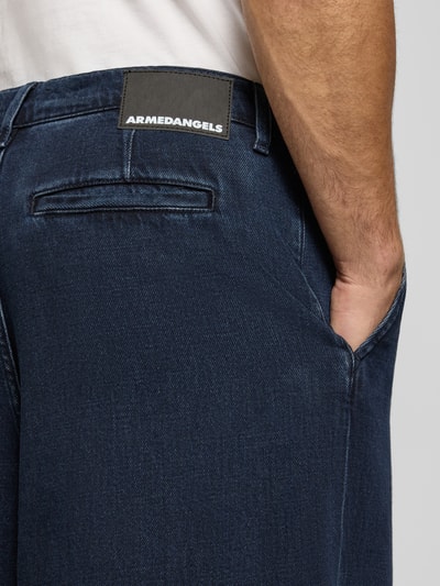 Mannenmodel draagt donkerblauwe baggy jeans uit pure katoen model 'Kaavo' van ARMEDANGELS, Heren baggy jeans, detailopname.