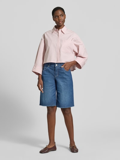 Frauenmodel trägt Jeansshorts mit Fransen Modell 'Rich' von MAC aus Baumwoll-Elasthan-Mix, Relaxed-Fit, Eingrifftaschen, blaue Farbe, Ganzkörperansicht von vorne.