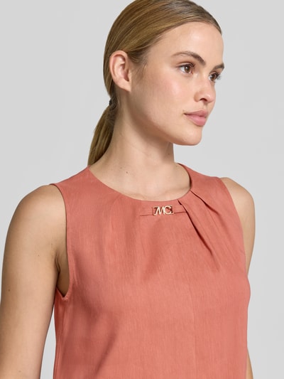Kobiecy model nosi Knielanges Businesskleid aus Leinen-Mix mit Label-Detail od Marc Cain, kolor łososiowy, dekolt okrągły z marszczeniem, tkanina z domieszką wiskozy, detal z logo, szerokość w rozmiarze 36: 44 cm, długość tyłu: 98 cm, krój prosty, zbliżenie na górną część ciała.