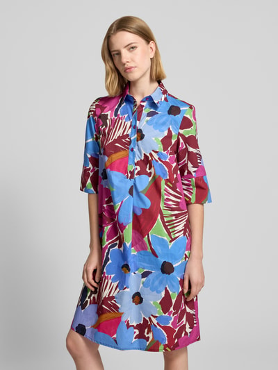 Frauenmodel trägt Relaxed Fit Midikleid mit floralem Allover-Print von Christian Berg Woman Selection aus Reine Baumwolle, Halbarm, Umlegekragen, Knopfleiste, farbenfrohe Muster in Blau, Rot und Grün, glatte Textur, Ganzkörperansicht von vorne. Rückenlänge bei Größe 36: 97 cm, Brustweite: 46 cm, Ärmellänge: 37 cm.