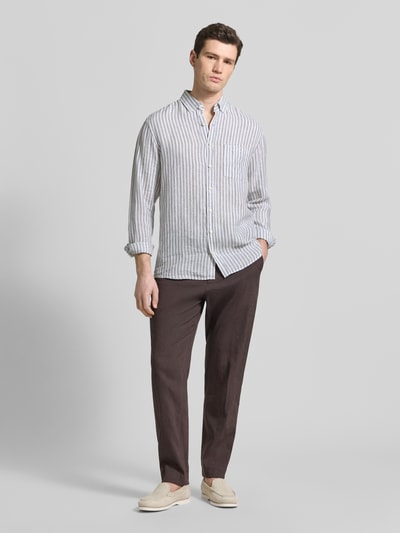 Męski model nosi Modern Fit Freizeithemd aus reinen Leinen Modell 'Daniel' od Brax, paski, listwa guzikowa, kołnierzyk typu button down, długość tyłu w rozmiarze M 76 cm, szerokość ramion w rozmiarze M 50 cm, długość rękawów w rozmiarze M 67 cm, materiał: len, całopostaciowy widok z przodu.