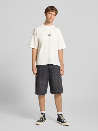 Männermodel trägt Relaxed Fit T-Shirt mit Logo-Print von REVIEW, cremefarben, Reine Baumwolle, Rundhalsausschnitt, Rückenlänge 68 cm, Herren T-Shirt, Ganzkörperansicht von vorne.