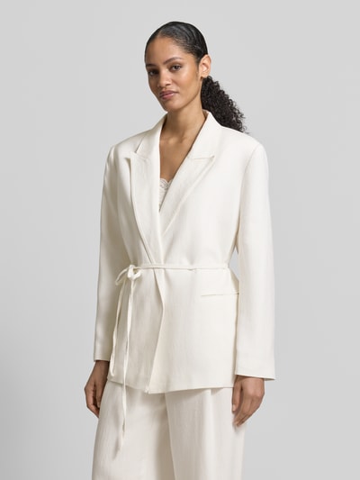 Frauenmodel trägt Anzugblazer mit Reverskragen von Jake*s Collection, taillierte Passform, Stoffband, Paspeltaschen, Nahaufnahme Oberkörper.