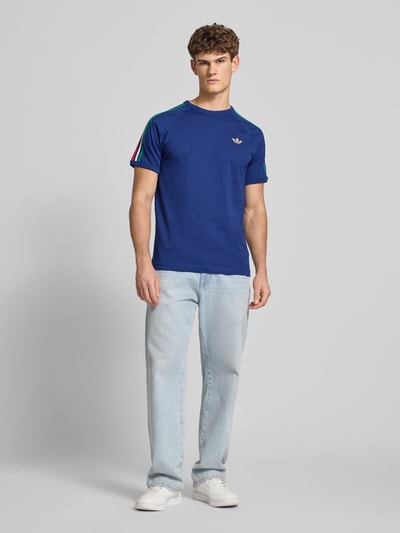 Männermodel trägt Regular Fit T-Shirt mit Kontraststreifen von adidas Originals, Optik: unifarben, Jersey, Ganzkörperansicht von vorne.