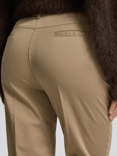 Frauenmodel trägt Hose mit Eingrifftaschen Modell 'Lorella' von Raphaela By Brax aus beigefarbenem Baumwoll-Mix, Nahaufnahme Rückansicht.