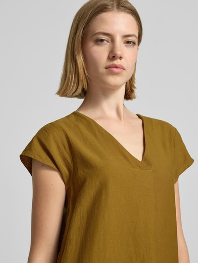Frauenmodel trägt Knielanges Leinenkleid mit V-Ausschnitt Modell 'Ina' von Soyaconcept im Leinen-Mix mit Viskose-Anteil, senfgelb, glatte Textur, Loose-Fit, Nahaufnahme Oberkörper.