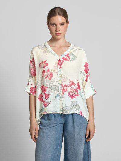 Frauenmodel trägt Relaxed Fit Bluse aus Viskose-Mix im Allover-Look von Comma in Creme mit floralen Mustern, Knopfleiste, V-Ausschnitt, 3/4-Arm, verlängertem Rückenteil, Ganzkörperansicht von vorne.
