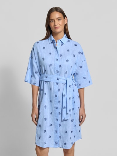 Frauenmodel trägt knielanges Hemdblusenkleid mit Bindegürtel Modell 'DERBY' von 0039 Italy, hellblau mit Stickereien, Leinen-Baumwoll-Mix, gerader Schnitt, Ganzkörperansicht von vorne.