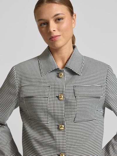 Frauenmodel trägt Boxy Fit Kurzblazer mit Vichy-Muster Modell 'ALERO-2' von HUGO, Optik: Allover-Muster, Umlegekragen, Langarm, einreihige Knopfleiste, Brustpattentaschen; Nahaufnahme Oberkörper.