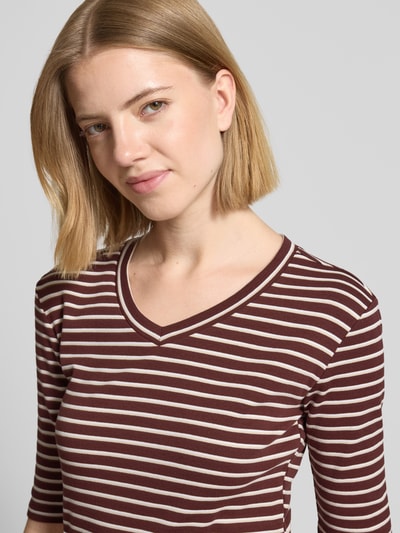 Kobiece model prezentuje Longsleeve mit 3/4-Arm und V-Ausschnitt von Christian Berg Woman, mieszanka bawełny z dodatkiem streczu, krój straight fit, dekolt w serek, rękaw o dł. 3/4, długość tyłu w rozmiarze S: 54 cm, brązowe i białe paski, gładka tekstura, zbliżenie na górną część ciała, widok z przodu.