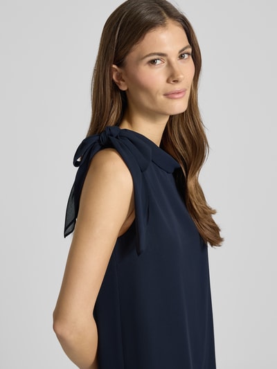 Modelka kobieca ma na sobie Sukienkę Relaxed Fit z stójką od Vera Mont, półprzezroczysty materiał, ozdobna kokarda, krój bez rękawów, halką pod sukienkę, długość tyłu w rozmiarze 36: 98 cm, szerokość w rozmiarze 36: 29 cm, ujęcie zbliżeniowe górnej części ciała z przodu.