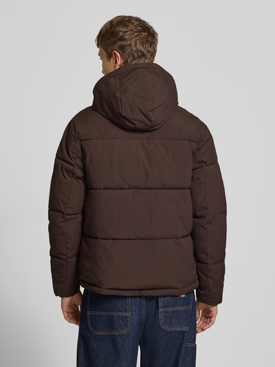 Männermodel trägt gewatteerd jack met capuchon Model 'GALAXY' van JACK & JONES in donkerbruin, regular fit, met steekzakken en ritssluiting, ruglengte bij maat M 70 cm, schouderbreedte 49 cm, borstwijdte 58 cm, mouwlengte 69 cm, ganzebodyaanzicht achterkant.