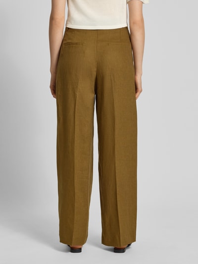Frauenmodel trägt Straight Fit Leinenhose mit Bügelfalten Modell 'Tempoli' von Mango in olivgrün, reine Leinen, Ganzkörperansicht Rückansicht.