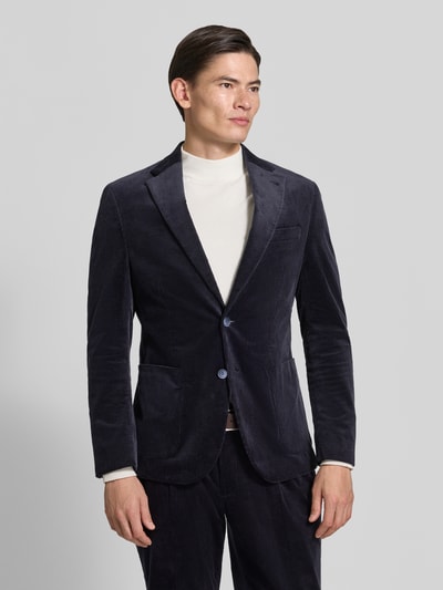 Męski model nosi Sakko in Cord-Optik mit seitlichen Eingrifftaschen von MCNEAL, bawełniana mieszanka ze stretchem, krój regular fit, ciemnogranatowy, długość tyłu w rozmiarze 50: 74 cm, szerokość w rozmiarze 50: 54 cm, długość rękawa w rozmiarze 50: 68 cm, tekstura sztruksowa, przód z guzikami oraz kieszenie boczne, widok całej sylwetki z przodu.
